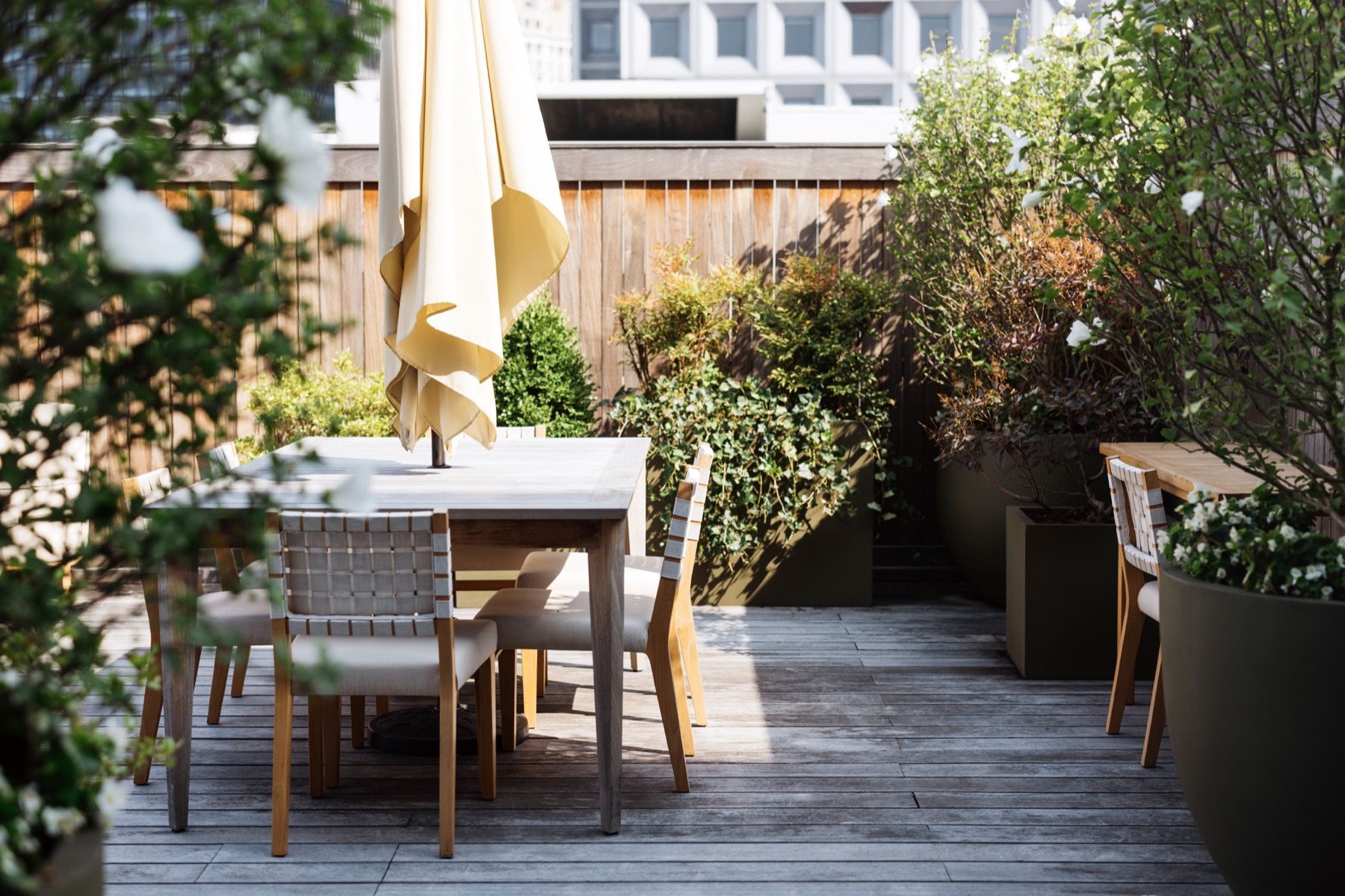 A wooden deck with a table and chairs and an umbrella