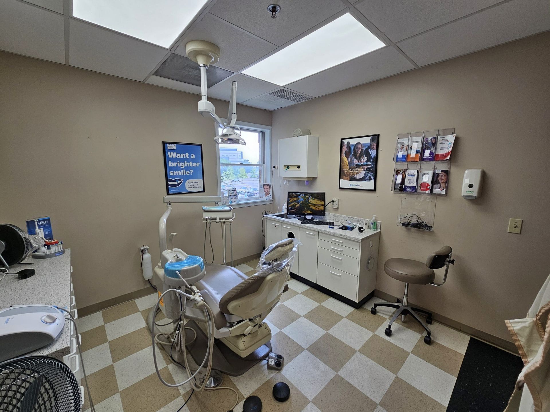 A dental office with a dental chair and a checkered floor.