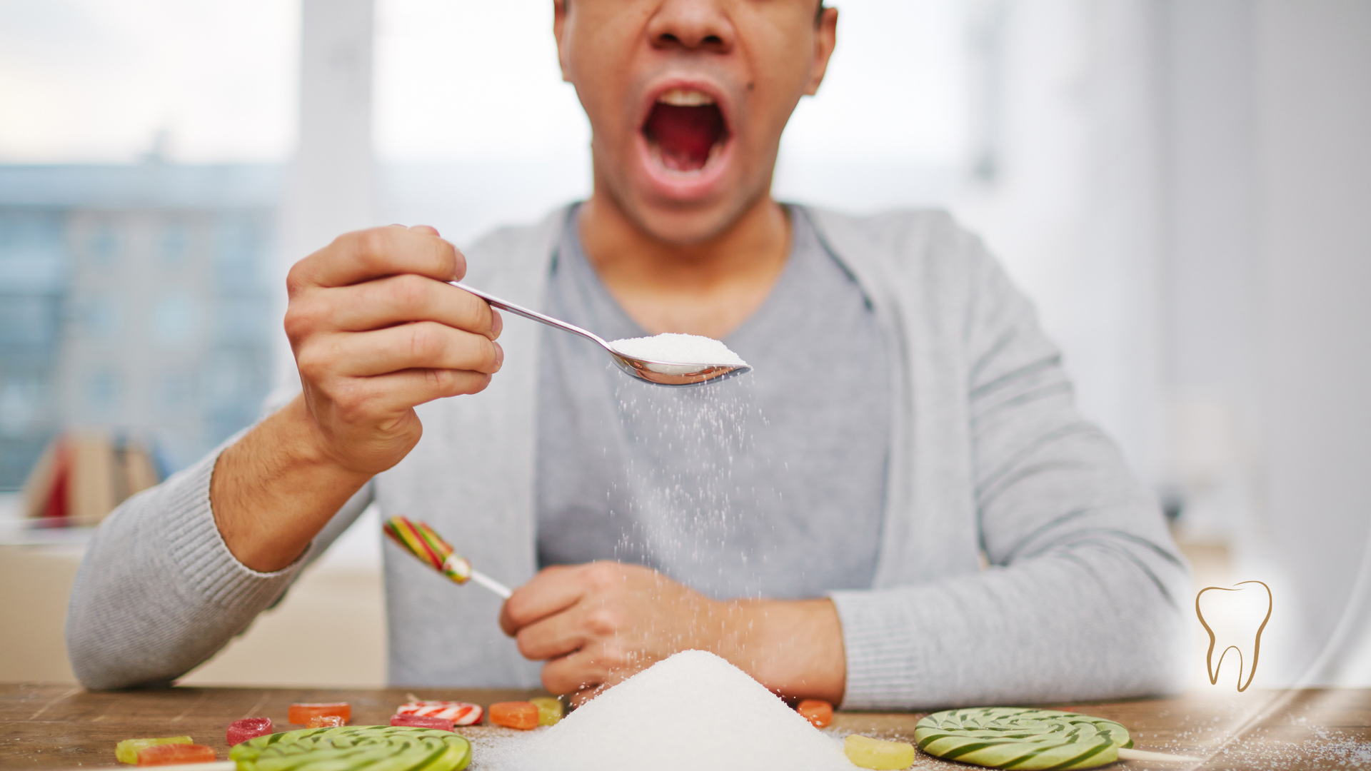 Man with mouth open about to eat spoonful of sugar, sweets on table, tooth icon.