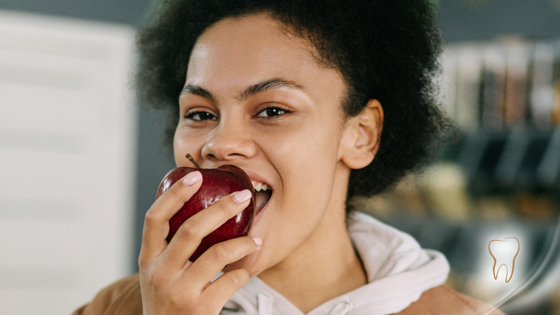A woman is biting into a red apple.