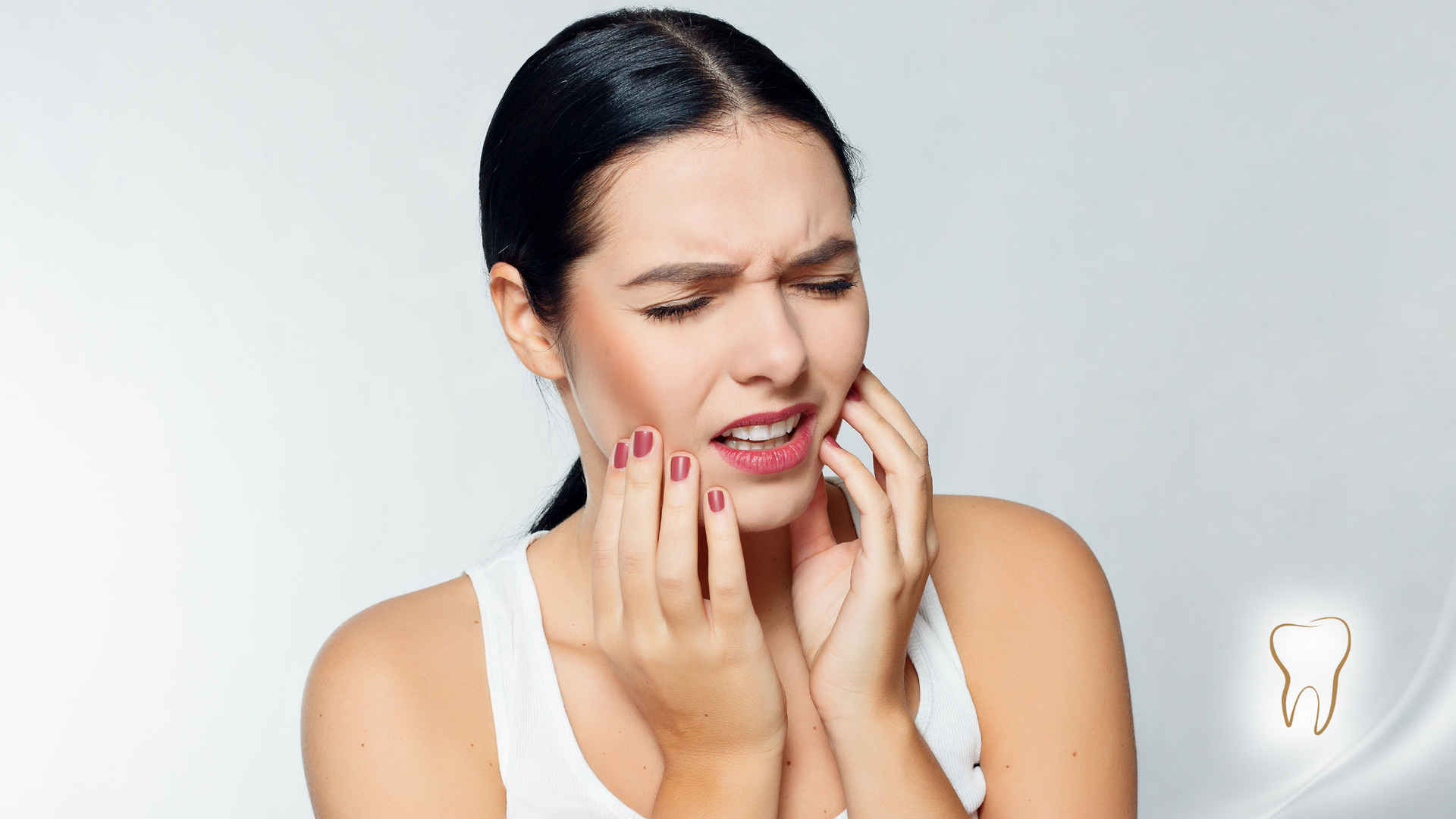 Woman in pain, holding her jaw, likely suffering from a toothache.