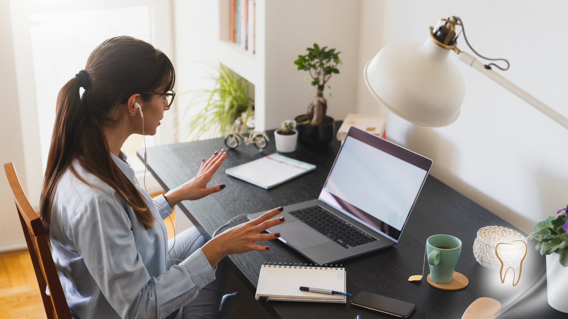 A woman is sitting at a desk using a laptop computer.