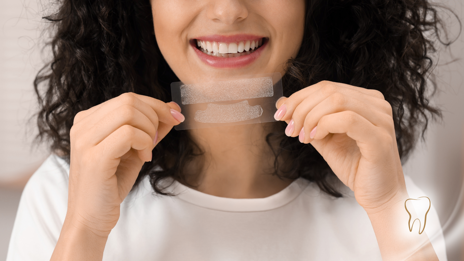 Woman holding teeth whitening strips, smiling.
