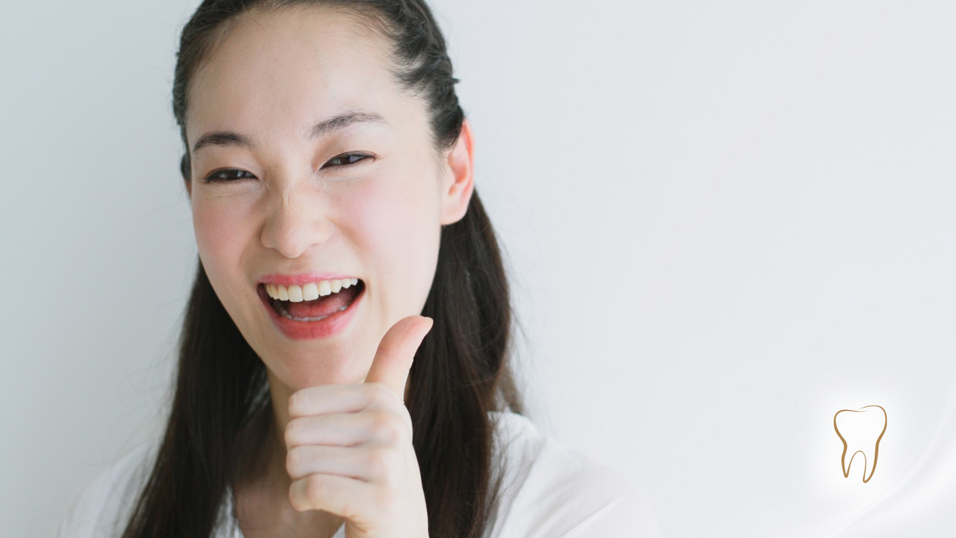 Woman smiling, giving a thumbs up, next to a glowing tooth icon.