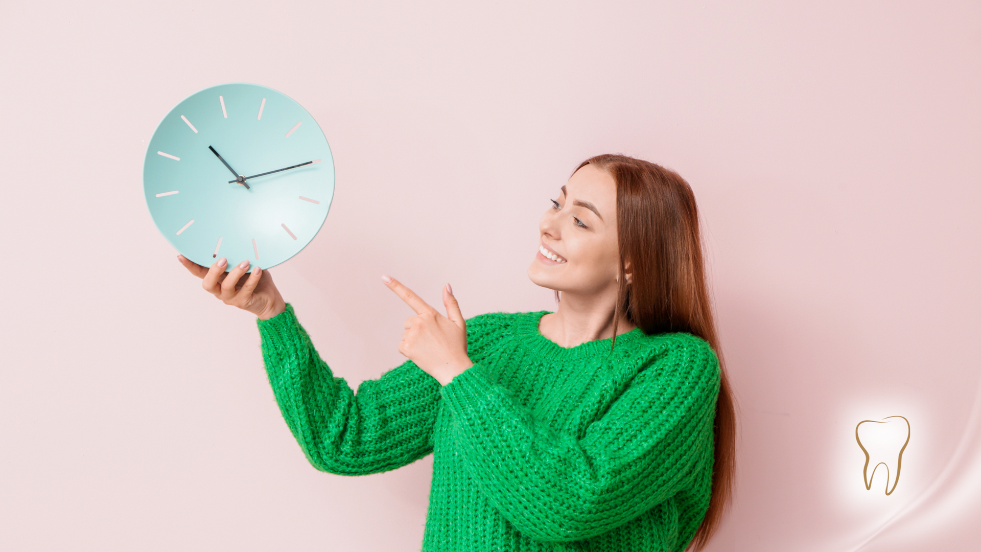 A woman in a green sweater is holding a clock and pointing at it.