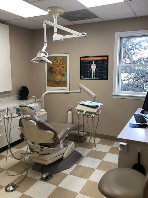 A dental office with a dental chair and a desk