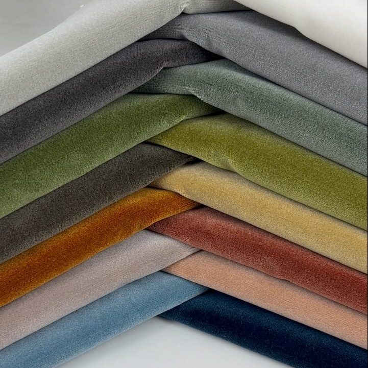 A bunch of different colored fabrics are stacked on top of each other.