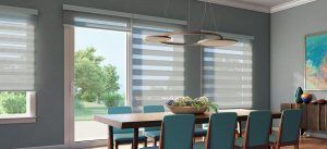 A dining room with a table and chairs and a sliding glass door.