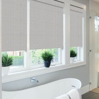 A bathroom with a tub and a window with blinds on it.