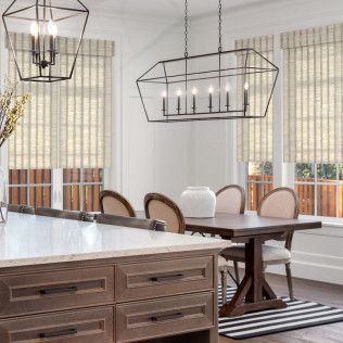 A dining room with a table and chairs and a chandelier hanging from the ceiling.