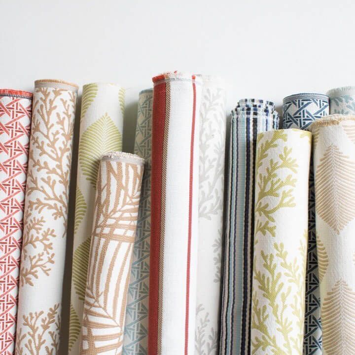Several rolls of fabric are lined up on a shelf