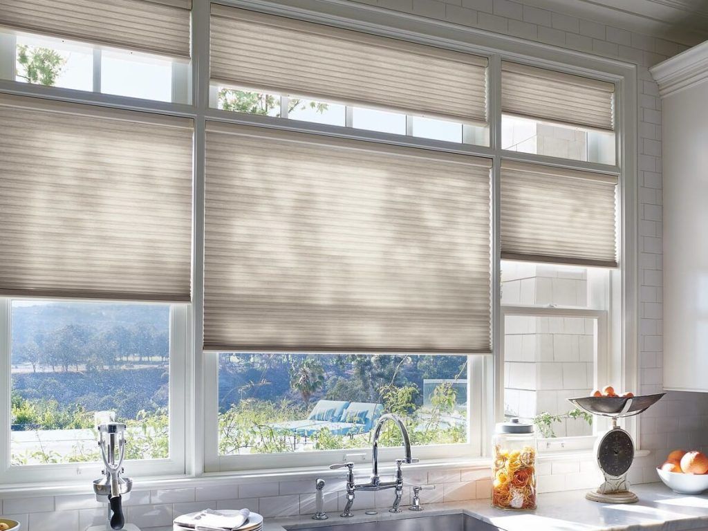 A kitchen with a sink and a window with blinds on it.