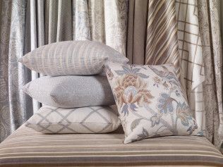 A stack of pillows sitting on top of each other on a bench.