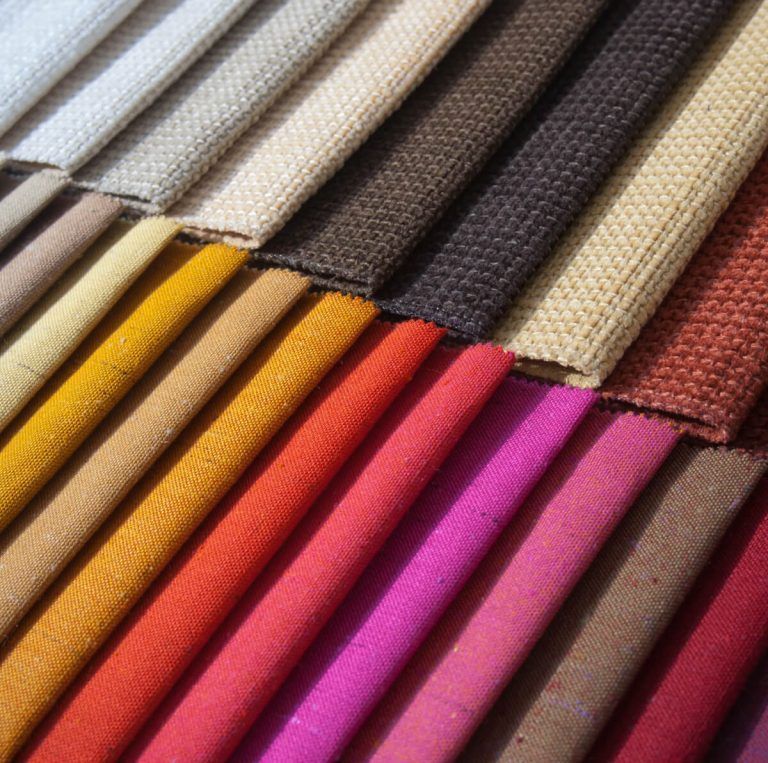 A bunch of different colored fabrics stacked on top of each other