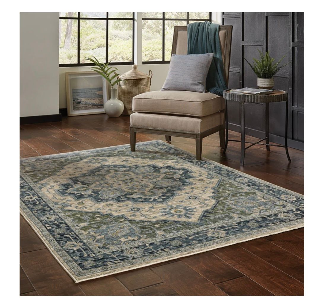 A living room with a chair and a rug on the floor.