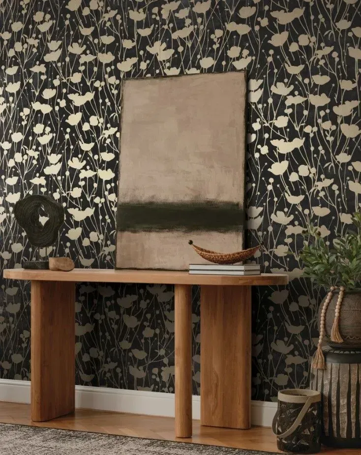 A painting is hanging on a wall above a wooden table.