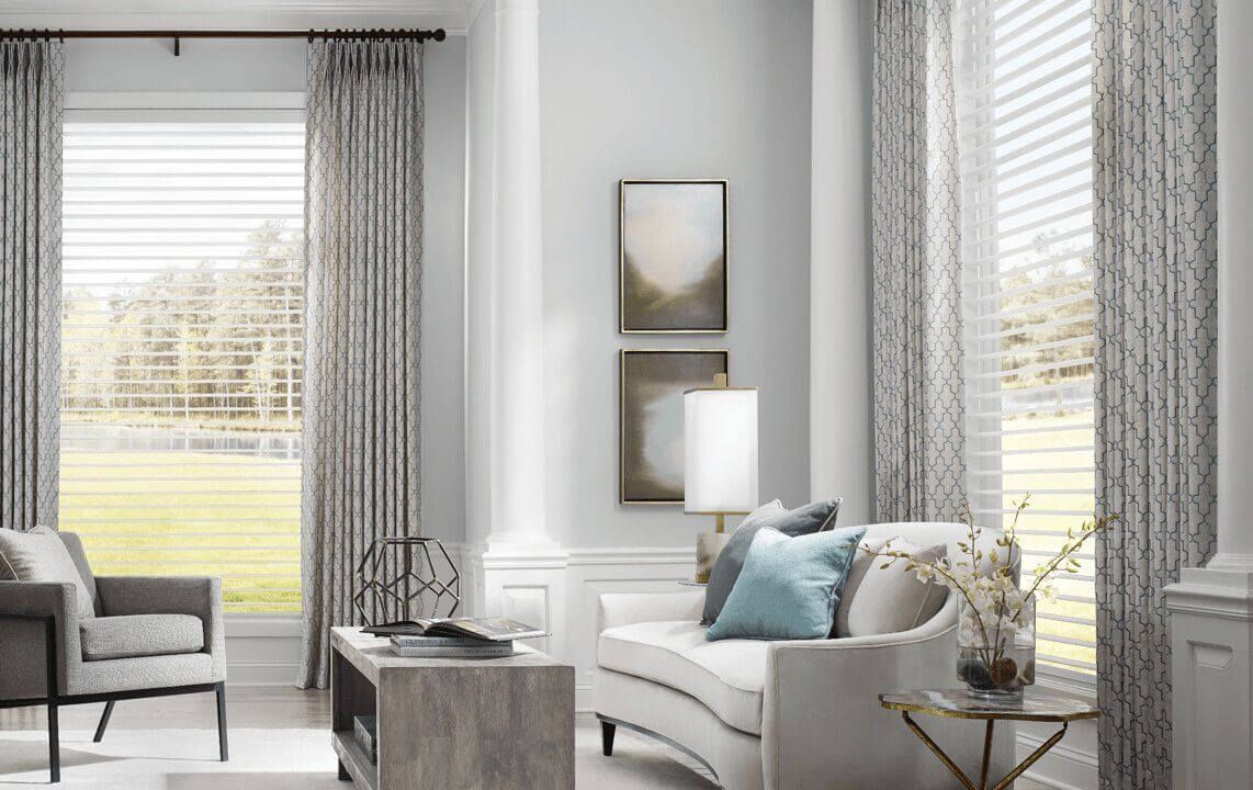 A living room with a couch , chair , table and windows.