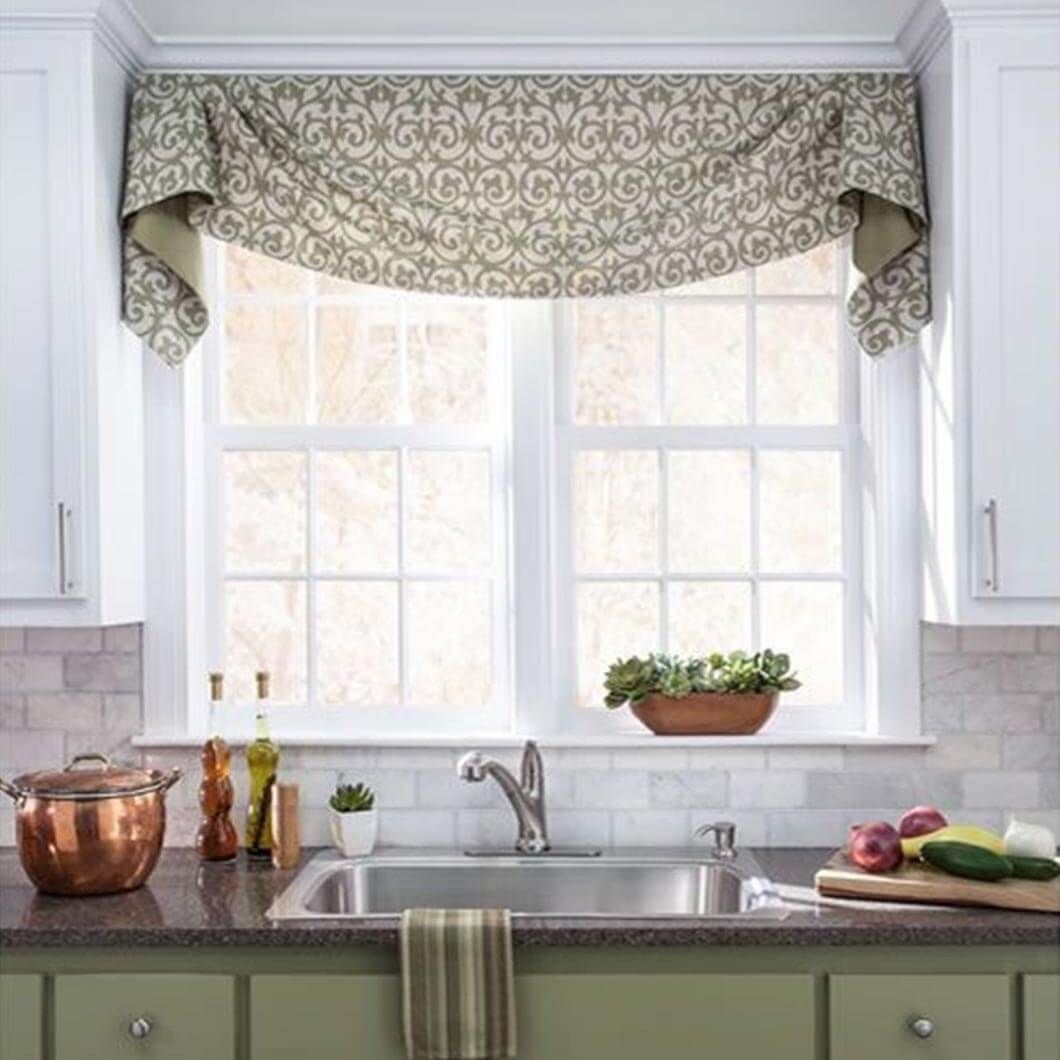 A kitchen with a sink , cabinets , and a window.