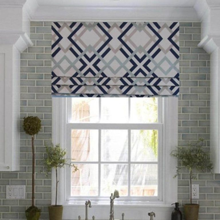 A kitchen window with a roman shade on it
