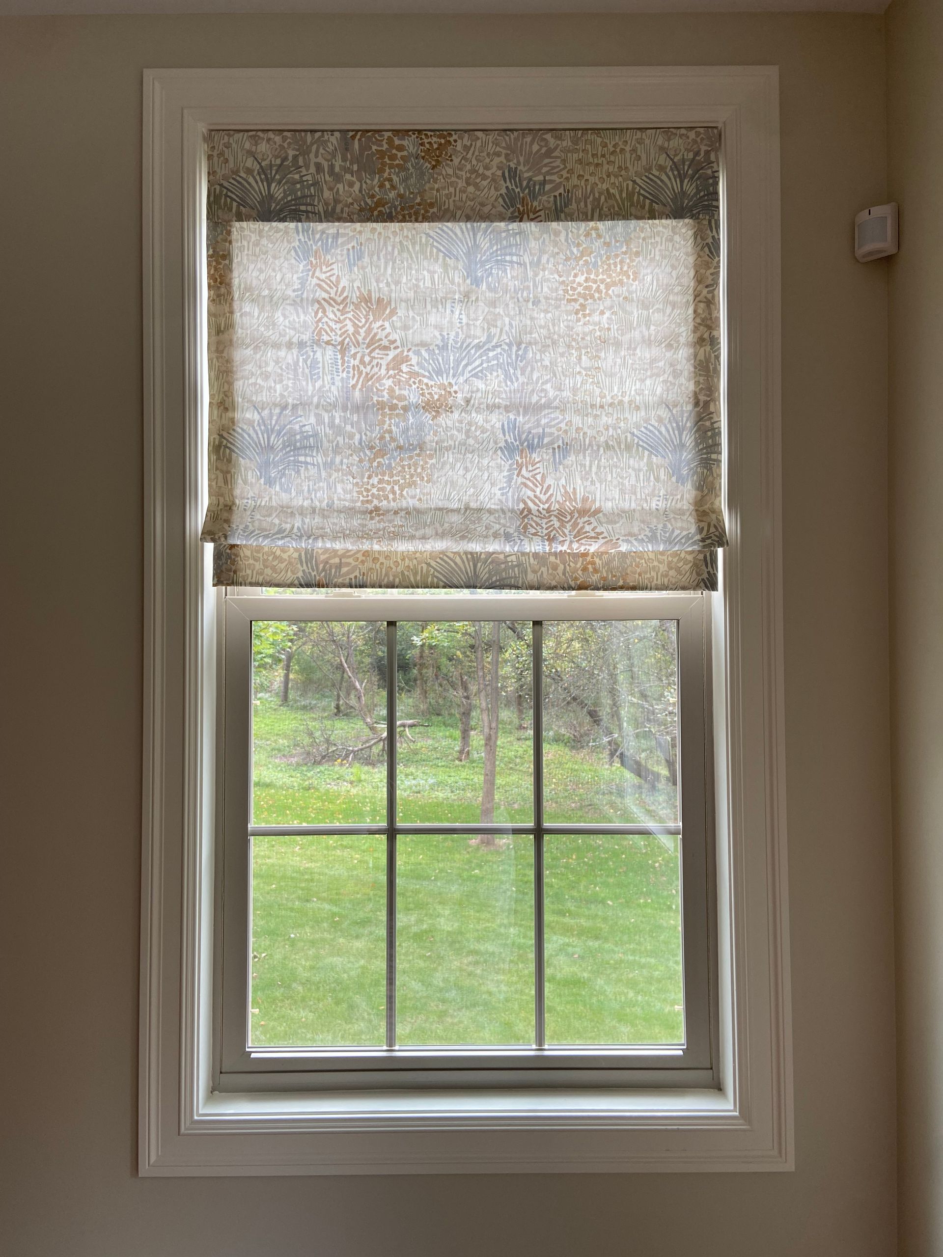A window with a roman shade on it in a room.
