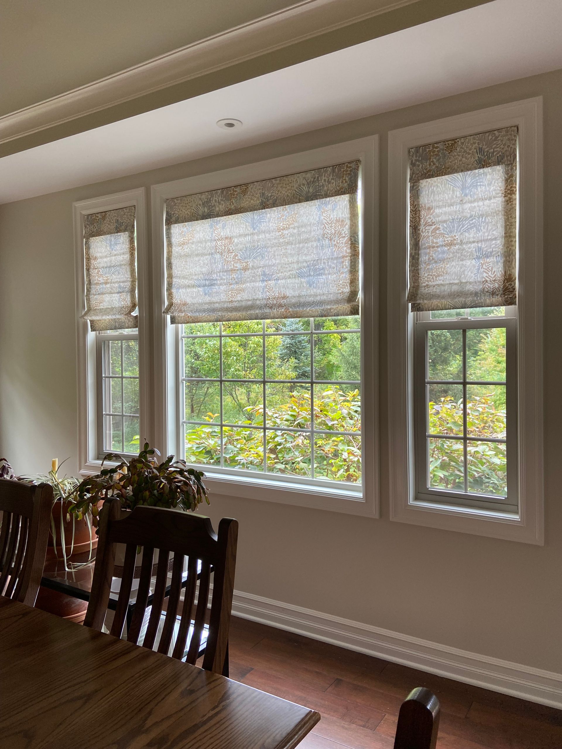 A dining room with a table and chairs and lots of windows