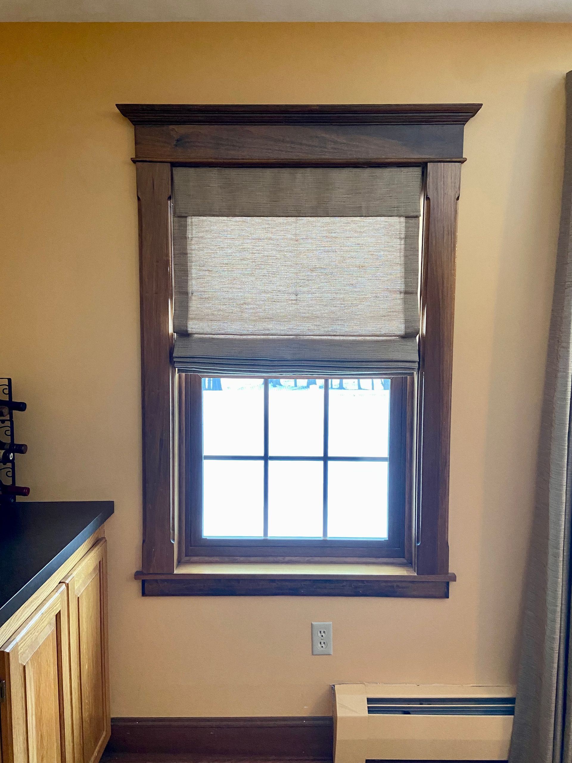 A window with a wooden frame and blinds in a kitchen