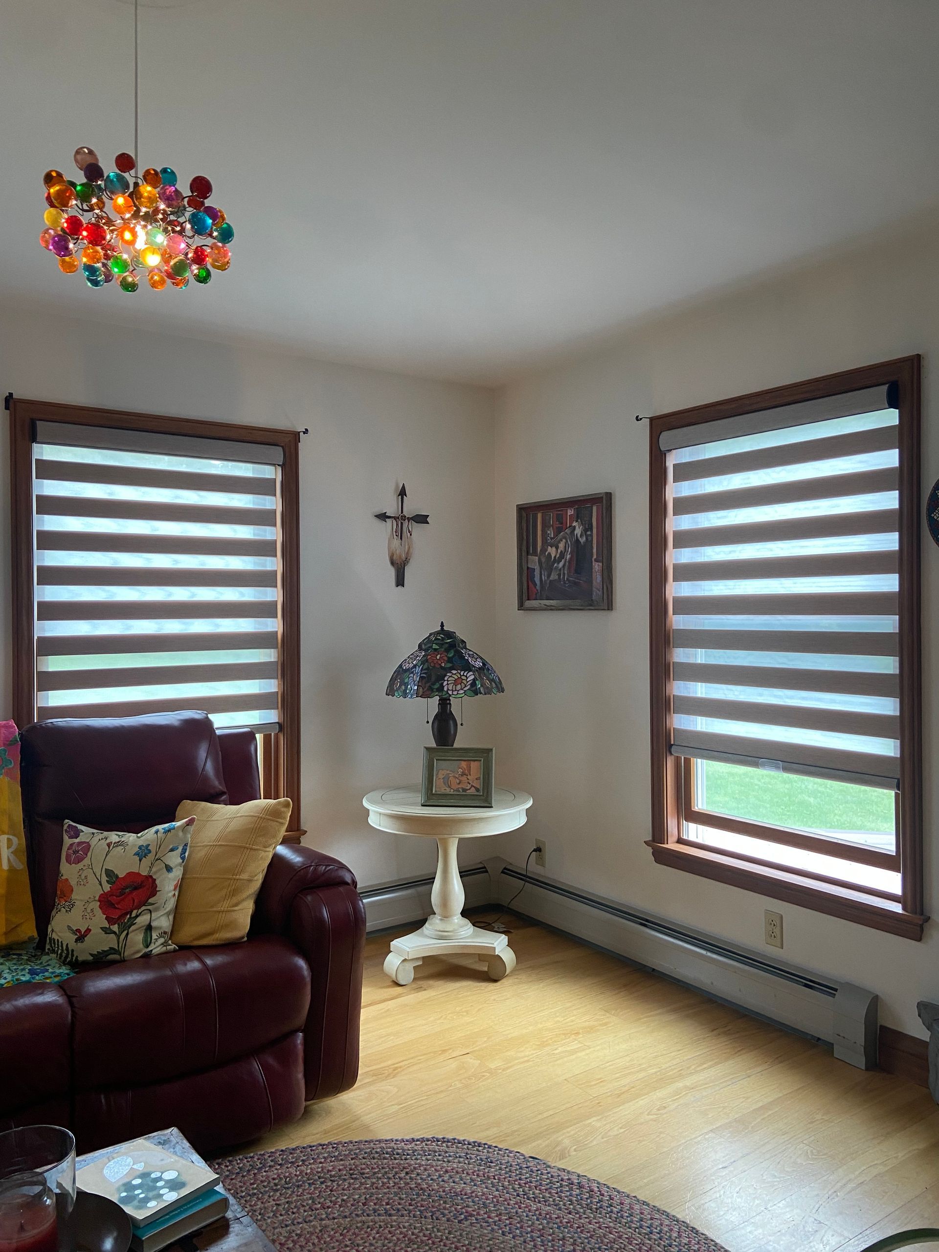 A living room with a couch , chair , table and a lamp.