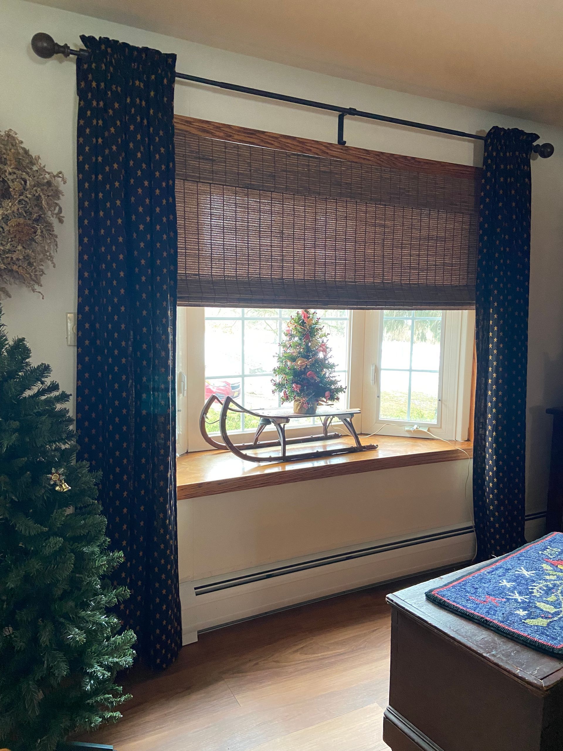 There is a christmas tree on the window sill in the living room.