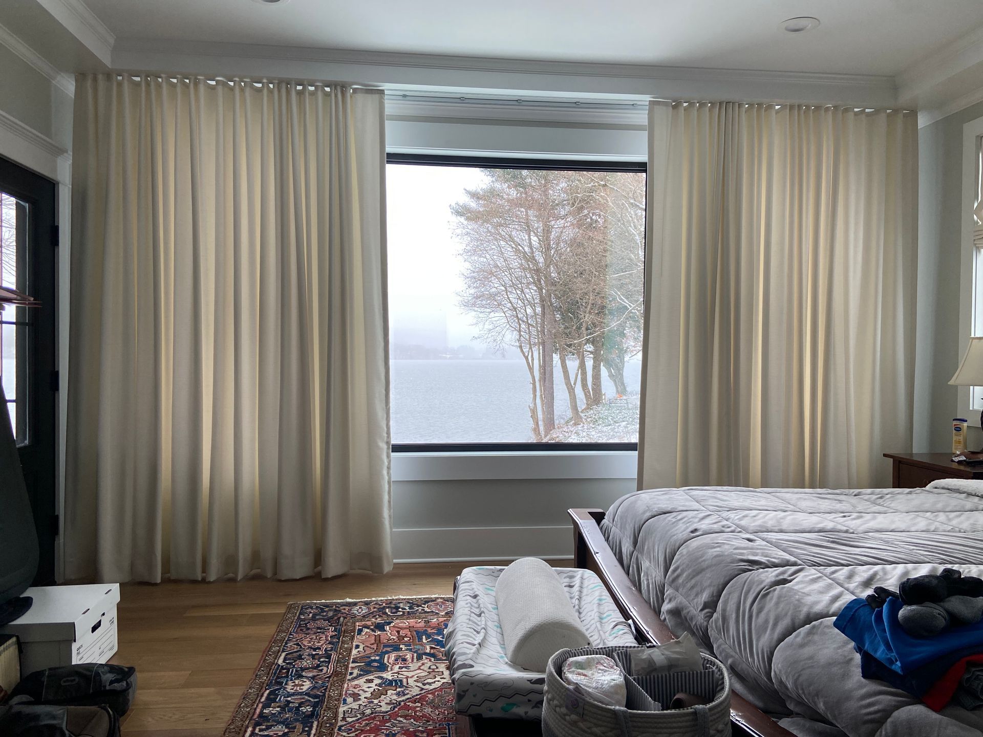 A bedroom with two beds and a large window.