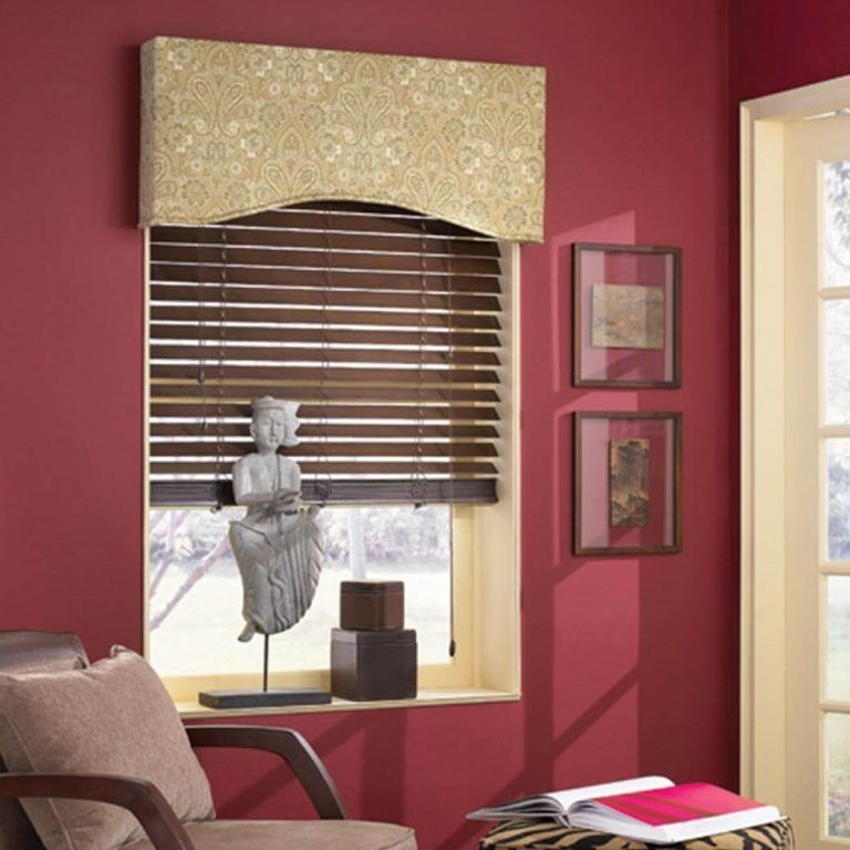 A living room with red walls and a window with blinds