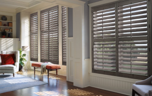 A living room with lots of windows and shutters on them