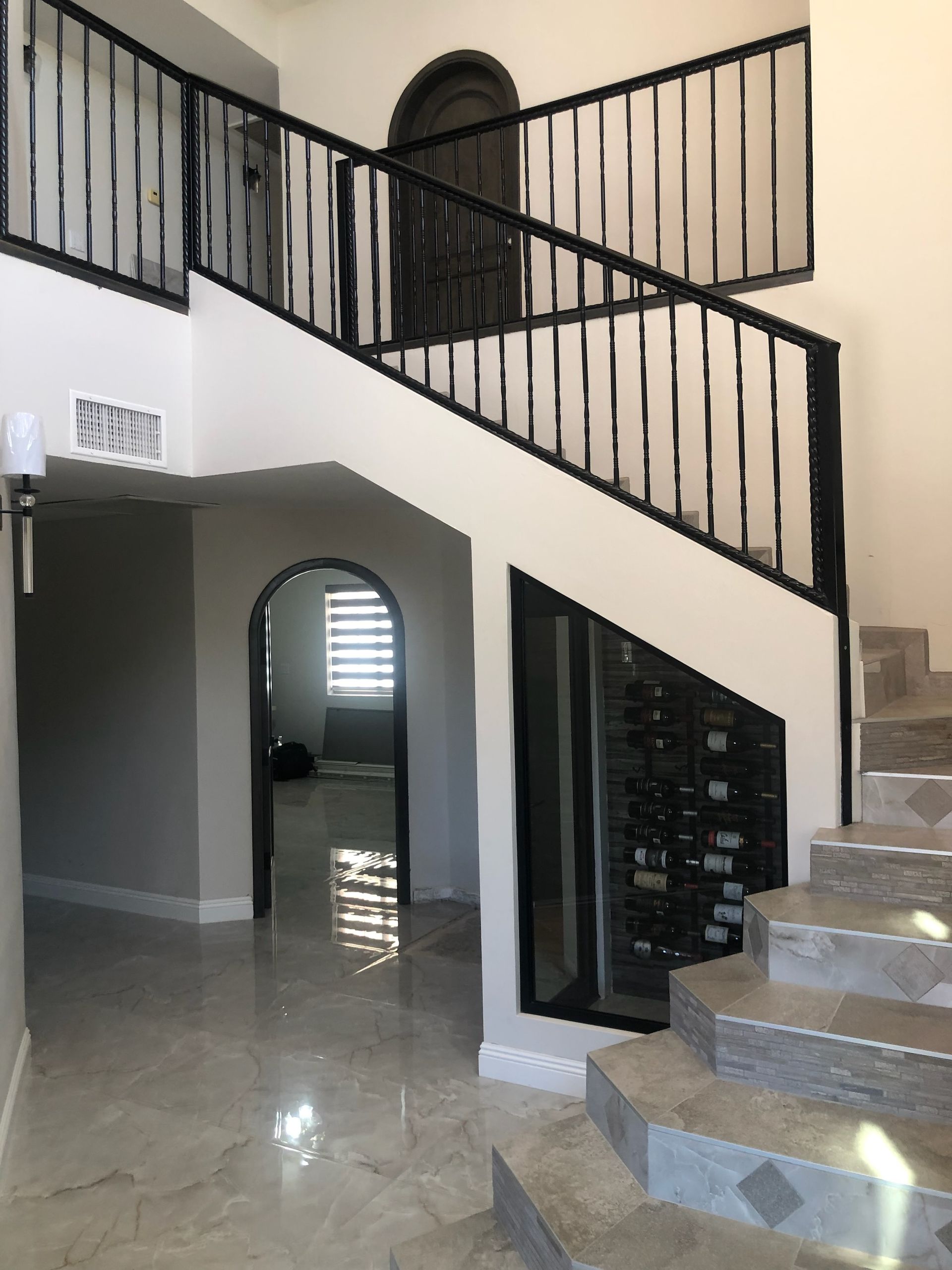A staircase with a wrought iron railing leading up to the second floor