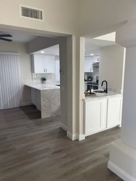 A kitchen with white cabinets and a sink in it