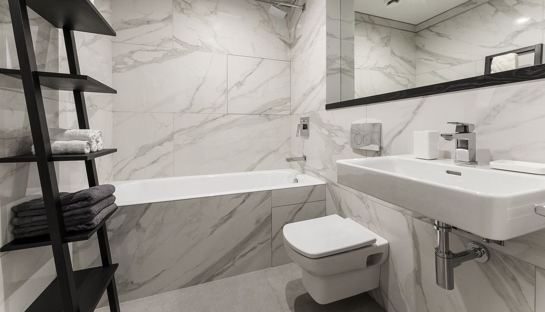 A bathroom with a sink , toilet , bathtub and mirror.