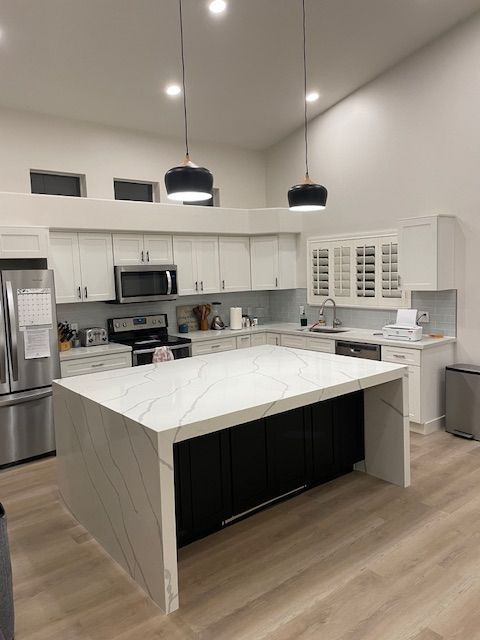 A kitchen with white cabinets and stainless steel appliances