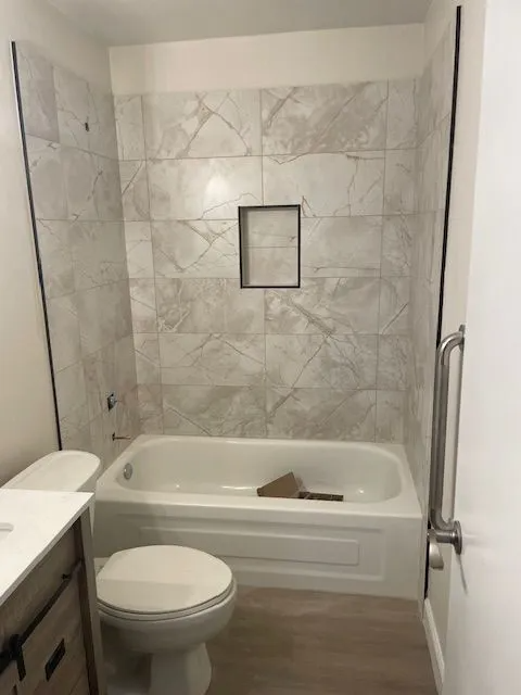 A bathroom with a toilet , bathtub and shower.