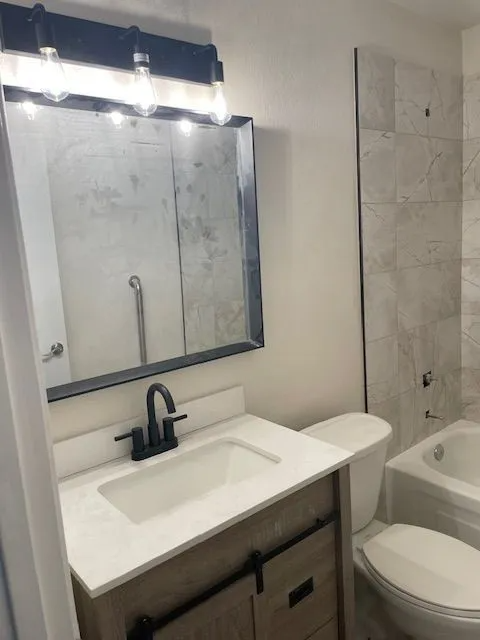A bathroom with a sink , toilet , tub and mirror