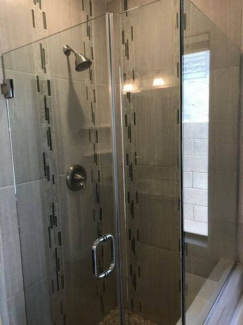 A bathroom with a glass shower door and a shower head.