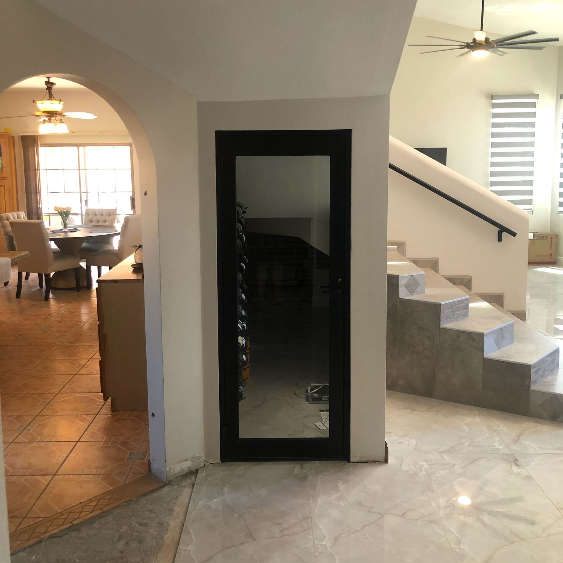 A hallway with stairs and a mirror on the wall