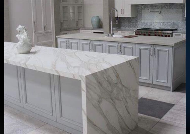 Kitchen with marble countertops and light gray cabinets.