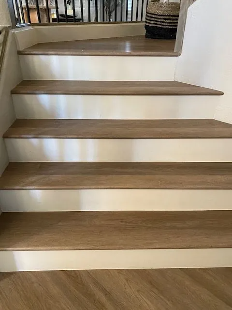 A set of wooden stairs with white steps in a house.