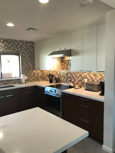 A kitchen with brown cabinets and white counter tops