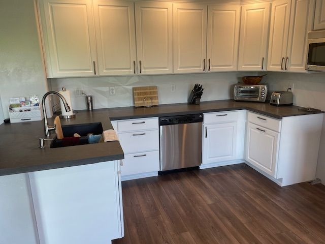 A kitchen with white cabinets and stainless steel appliances.