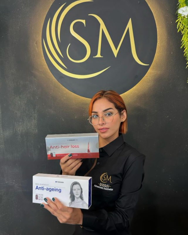 Una donna che tiene due scatole davanti a un logo piccolo