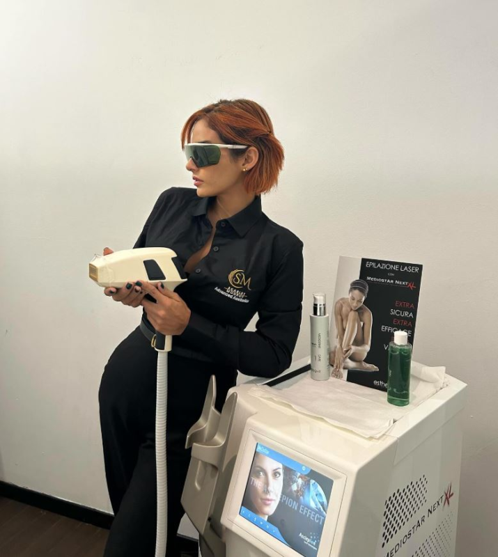 Una donna che indossa occhiali da sole tiene in mano una macchina