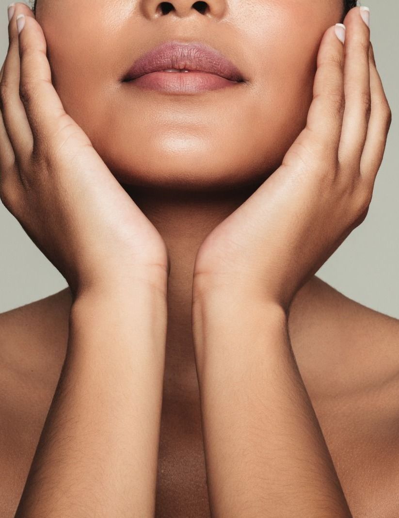 Un primo piano del viso di una donna con le mani sul viso