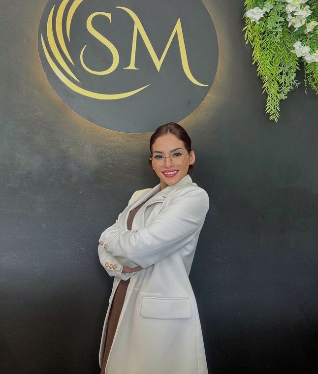 Una donna è in piedi davanti a un cartello che dice