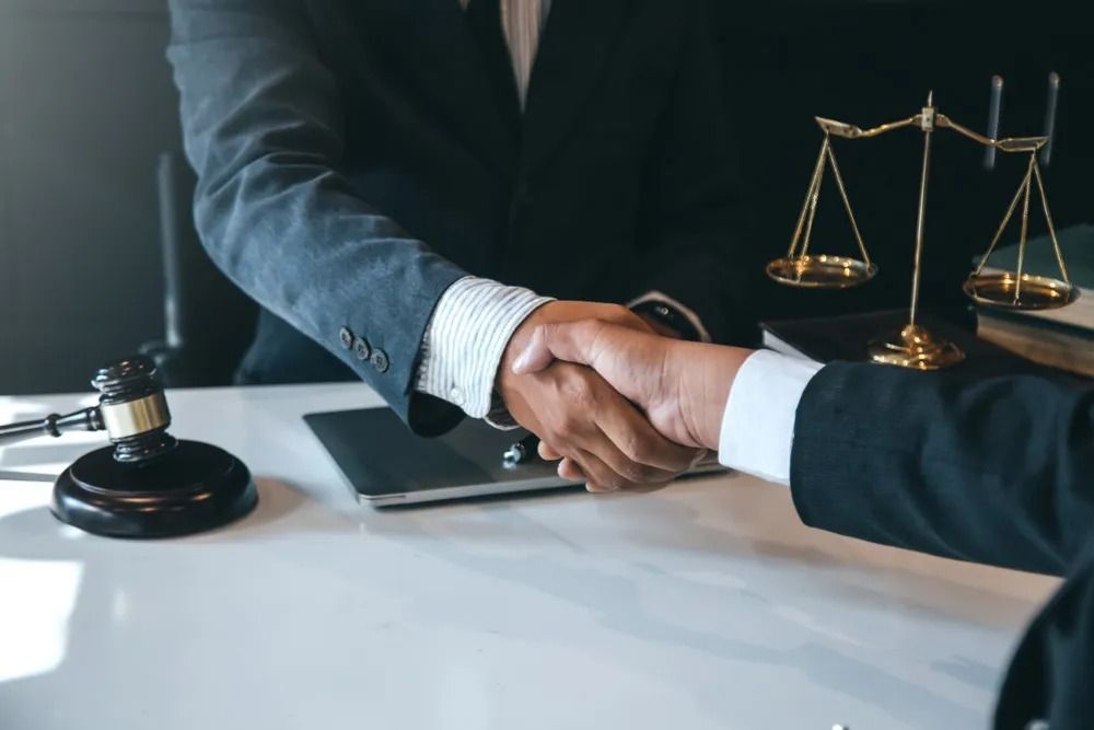 Business Handshake Between Two People at a Desk — Adamson Town Planning in Noosaville, QLD