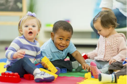 A Group Of Children Are Laying On The Floor In A Row