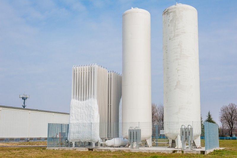 A group of white tanks sitting next to each other in a field.